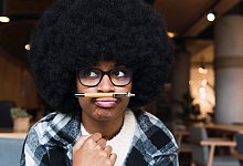 Eine junge Frau balanciert einen Stift auf der Oberlippe - Novellimage/Westend61/dpa-tmn