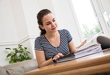 Ein Frau schaut in einen Aktenordner - Christin Klose/dpa-tmn