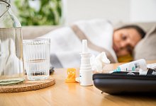 Eine Frau liegt mit einer Erkältung auf dem Sofa - Christin Klose/dpa-tmn