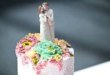 Die Figur eines Brautpaares steht auf einer Hochzeitstorte - Felix Kästle/dpa/dpa-tmn