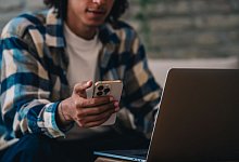 Ein Mann h&auml;lt ein Iphone in der Hand - Zacharie Scheurer/dpa-tmn