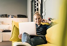 Frau sitzt mit Laptop auf einer Couch - Uwe Umstätter/Westend61/dpa-tmn