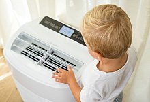 Junge steht vor einer Klimaanlage - Christin Klose/dpa-tmn