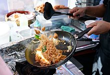 Ein Koch auf dem Thai-Streetfood-Markt - Bernd von Jutrczenka/dpa/dpa-tmn