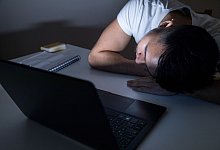 Mann legt erschöpft seinen Kopf auf den Tisch - Christin Klose/dpa-tmn