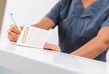 Ein Bonusheft wird in einer Zahnarztpraxis ausgefüllt - Benjamin Nolte/dpa-tmn