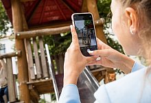 Eine Mutter fotografiert ihr Kind auf einem Spielplatz - Christin Klose/dpa-tmn