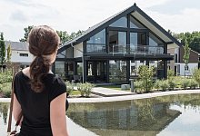 Eine Frau schaut auf ein Wohnhaus - Daniel Maurer/dpa-tmn