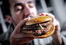 Mann beißt in einen Burger - Sina Schuldt/dpa/dpa-tmn