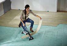 Frau verlegt Boden auf einer Trittschalldämmung - wolfcraft/DIY Academy/dpa-tmn