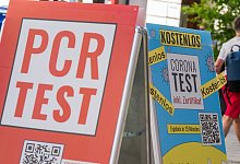 Schilder bewerben vor dem Eingang einer Apotheke in der M&uuml;nchener Innenstadt Corona-Tests. - Peter Kneffel/dpa