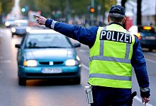 Ein Polizist stoppt ein Fahrzeug - Foto: Ralf Hirschberger/dpa-Zentralbild/dpa-tmn