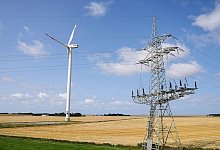 Windrad und Strommast - Frank Molter/dpa