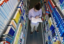 Student liest in der Uni-Bibliothek in einem Buch - Markus Scholz/dpa-tmn