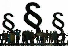 Symbolbild mit Menschen und Paragrafen - Robert Guenther/dpa-tmn/dpa