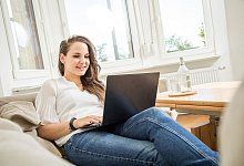 Eine Frau mit Laptop auf dem Sofa - Christin Klose/dpa-tmn
