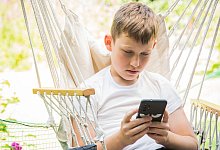 Junge schaut auf sein Smartphone - Christin Klose/dpa-tmn