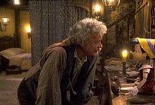 Tom Hanks (l) als Holzschnitzer Geppetto beugt sich zum computeranimierten Pinocchio herunter. - Courtesy Of Disney Enterprises/dpa