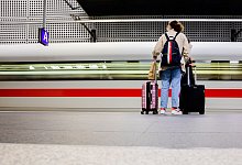 Ein Fahrgast steht vor einem abfahrenden ICE - Christoph Soeder/dpa/dpa-tmn