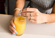 Eine Person greift nach einem Glas Orangensaft - Christin Klose/dpa-tmn