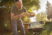 Ein Mann grillt Burger - Christin Klose/dpa-tmn