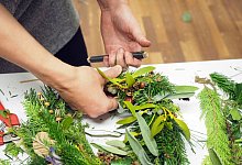 Eine Person bastelt einen Kranz - C. Strobl-Lopez/Natur im Garten/dpa-tmn