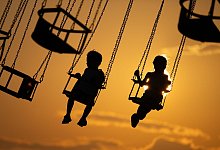 Zwei Kinder in einem Kettenkarussell - Sebastian Kahnert/dpa/dpa-tmn