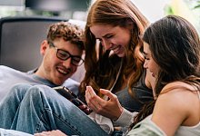 Junge Menschen gucken auf Smartphone - Zacharie Scheurer/dpa-tmn