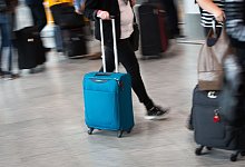 Passagier mit Handgepäck geht durch den Flughafen in Frankfurt - Frank Rumpenhorst/dpa-tmn