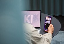 Ein Mann nutzt einen KI-Assistenten auf einem iPad und iPhone - Nico Tapia/dpa-tmn