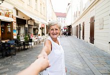 Frau lächelt bei einem Ausflug in Bratislava - Halfpoint/Westend61/dpa-tmn