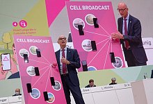 Der Vorstandvorsitzende der Deutsche Telekom, Timotheus H&ouml;ttges, demonstriert bei der Hauptversammlung des Unternehmens im April das Cell Broadcast System. - Henning Kaiser/dpa