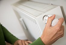 Eine Frau dreht eine Heizung auf - Christin Klose/dpa-tmn