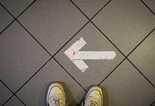 Ein Pfeil aus Klebeband ist auf einem Fu&szlig;boden zu sehen - Sebastian Willnow/dpa/dpa-tmn