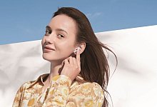 Eine Frau mit den Huawei Freebuds 5i - Huawei/dpa-tmn