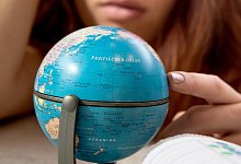 Reiseplanung an einem kleinen Globus - Foto: Franziska Gabbert/dpa-tmn