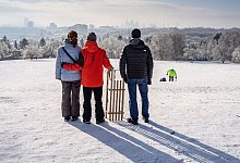 Eine Familie steht mit ihrem Schlitten auf dem Lohrberg - Frank Rumpenhorst/dpa/dpa-tmn
