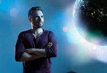 Mann schaut zu einer animierten Erdkugel - Philipp Dimitri/Westend61/dpa-tmn