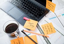 Chaos auf dem Schreibtisch mit Laptop, USB-Stick und Notizen - Christin Klose/dpa-tmn