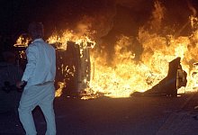 Brennendes Auto auf der Stra&szlig;e vor dem zentralen Asylbewerberheim von Mecklenburg-Vorpommern in Rostock-Lichtenhagen. - picture alliance / Bernd W&uuml;stneck/dpa