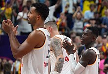 Die deutschen Basketballer um Dennis Schröder (r) bedanken sich nach dem Sieg gegen Montenegro beim Berliner Publikum. - Soeren Stache/dpa