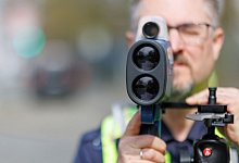 Ein Polizist mit einem Lasermessgerät - Daniel Karmann/dpa