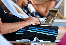 Ein Urlauber am Laptop - Andrea Warnecke/dpa-tmn