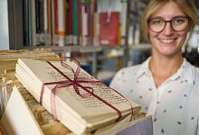 Birte-Carola Gnau-Franké, Geschäftsführende Leiterin der Liebesbrief-Archivs, trägt im Liebesbrief-Archiv in der Bibliothek der Universität Koblenz einen Koffer mit historischen Liebesbriefen. - Thomas Frey/dpa