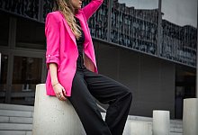 Eine junge Frau trägt einen Neon Pink Blaser - Christin Klose/dpa-tmn