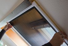 Ein Mann bringt ein Fliegengitter an einem Fenster an - Silvia Marks/dpa-tmn