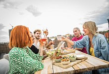 Ein Gruppe von Leuten sitzt auf einer Dachterrasse - Christin Klose/dpa-tmn