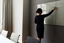 Eine Frau steht in einem Konferenzraum an einem Whiteboard - Annette Riedl/dpa/dpa-tmn