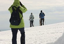 Wanderer gehen &uuml;ber den schneebedeckten Brocken - Matthias Bein/dpa/dpa-tmn