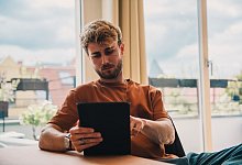 Mann mit Tablet - Zacharie Scheurer/dpa-tmn